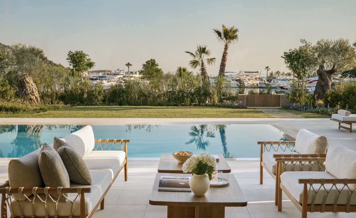 Terrace and private pool of a three-bedroom villa at Sani Asterias, with palm trees and the yachts of Sani Marina beyond