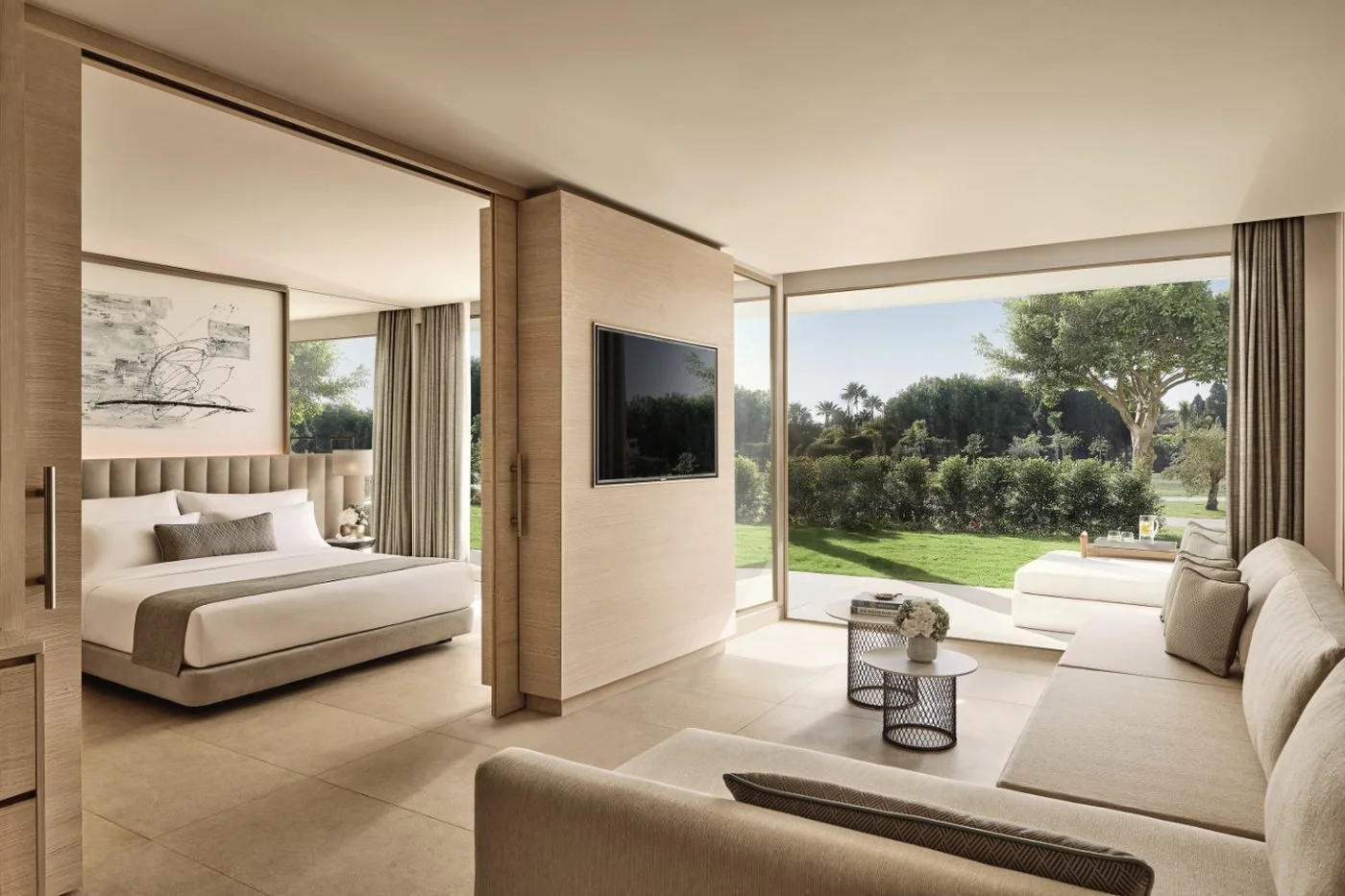 A One Bedroom Suite Private Garden with a living room opening onto a lawn and trees