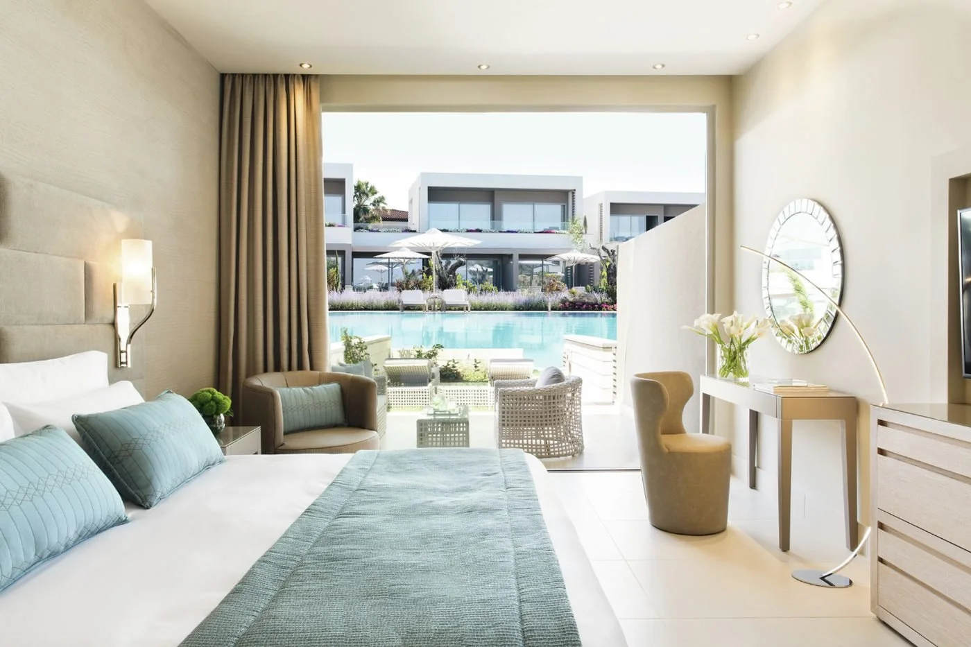 A Double Room Private Garden at Sani Dunes, with the bed facing a terrace and the lagoon pool