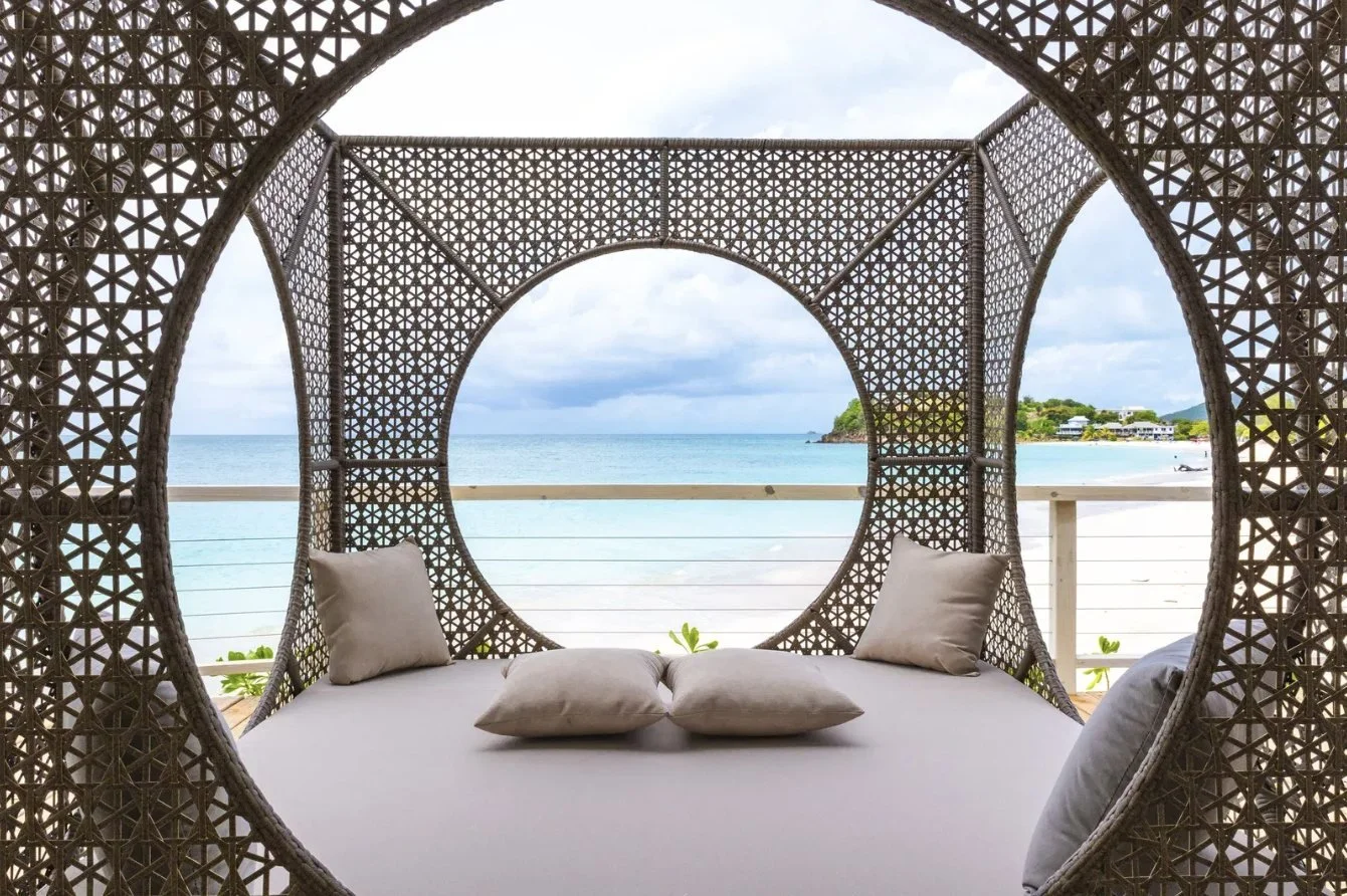 A wellness daybed in a woven frame overlooking the beach
