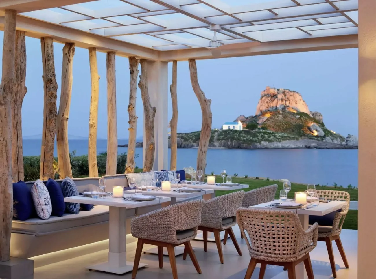 Candlelit tables at Ouzo restaurant looking out to Kastri island at dusk