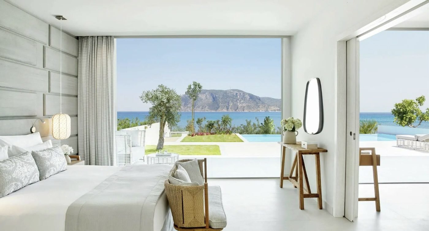 A bedroom in a Deluxe Two Bedroom Bungalow Suite looking out to its private pool and the sea