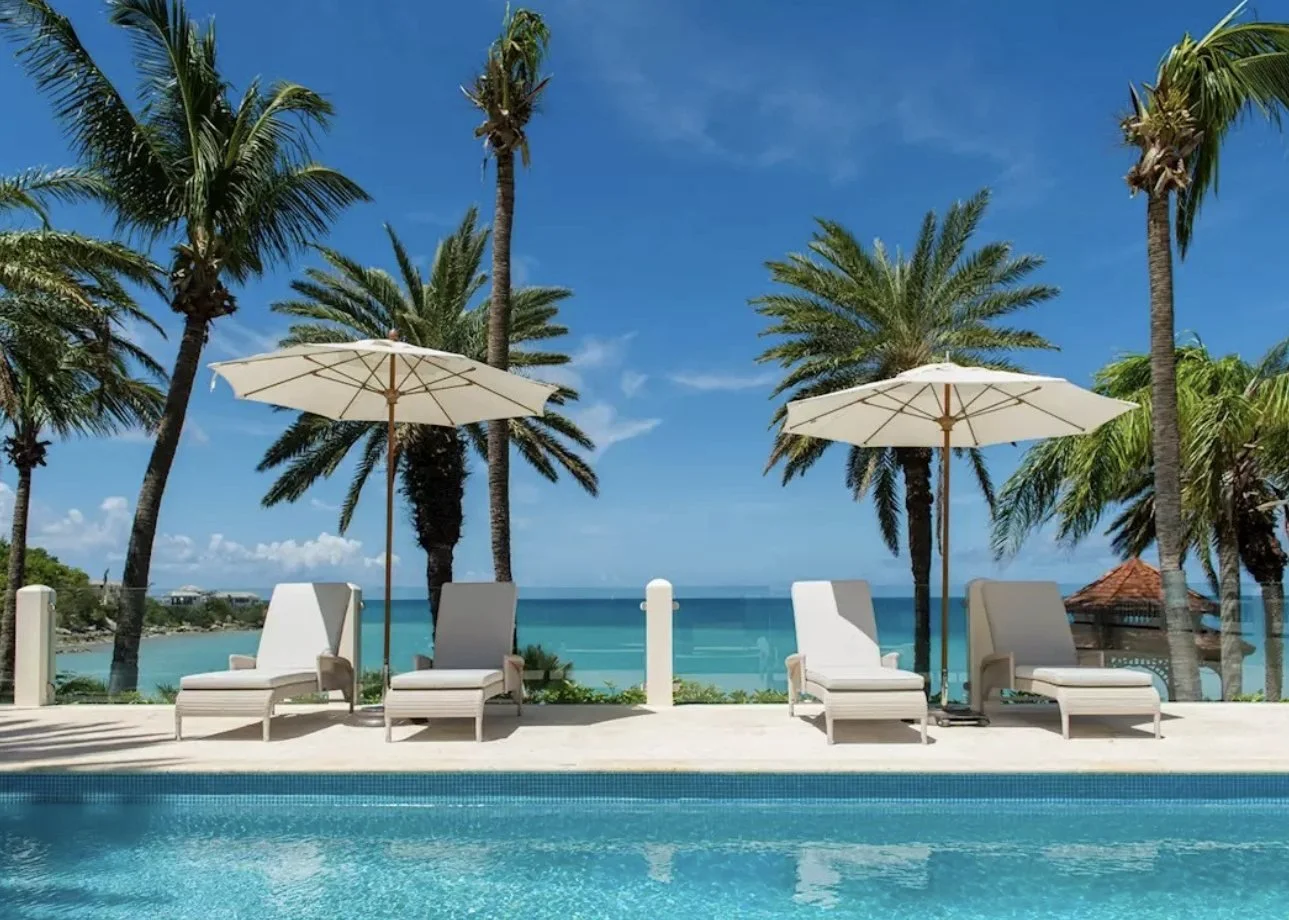 Poolside loungers under palms looking out to the sea at Blue Waters