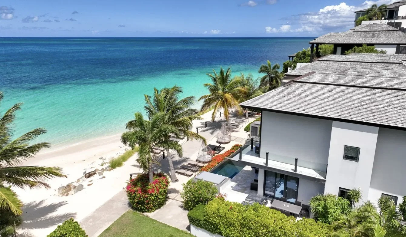 A beach house above white sand and turquoise water