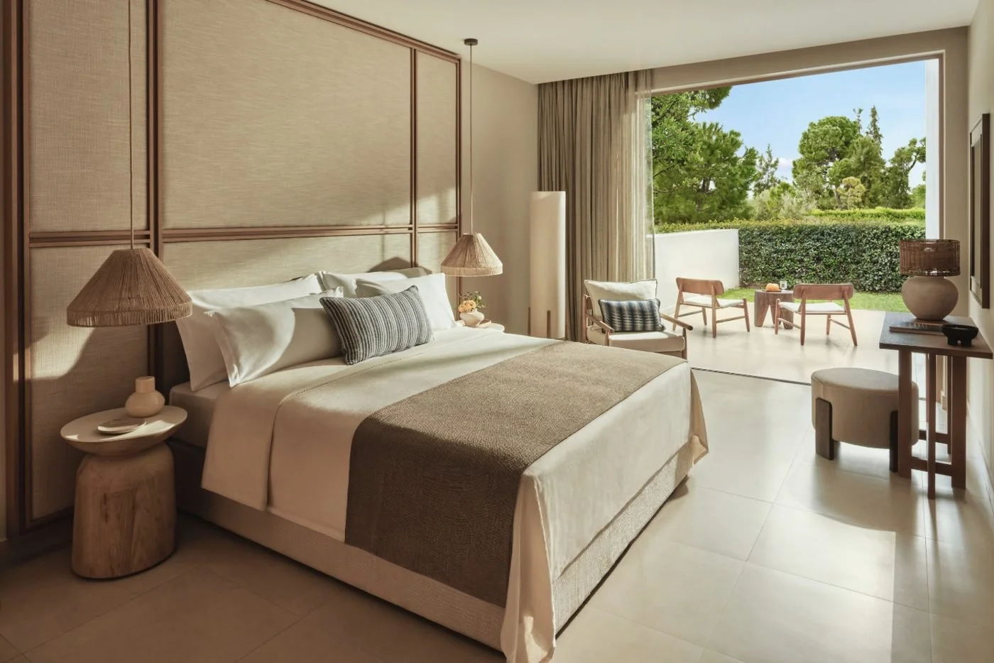 A Double Bungalow at Ikos Olivia with its glass doors open to a private terrace and garden