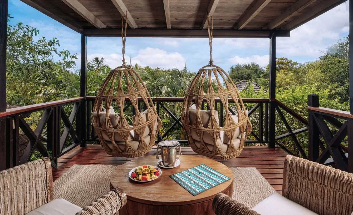 A shaded terrace with hanging egg chairs