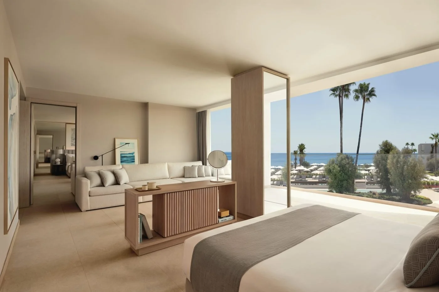 A Family Suite at Ikos Andalusia with a living area, a hallway to further bedrooms and a balcony over the pools and the sea