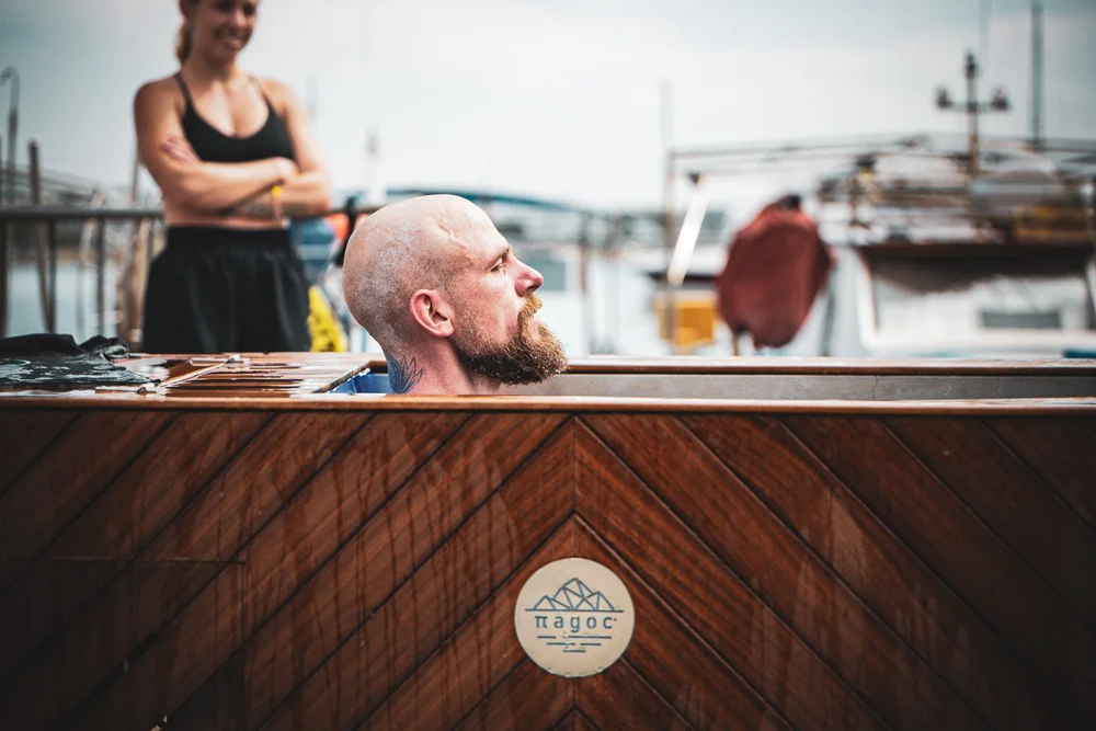 Man in a Pagoc hand-built Iroko ice bath at a Cyprus marina