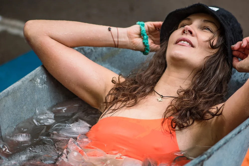 Smiling woman relaxing in an ice bath during cold exposure practice