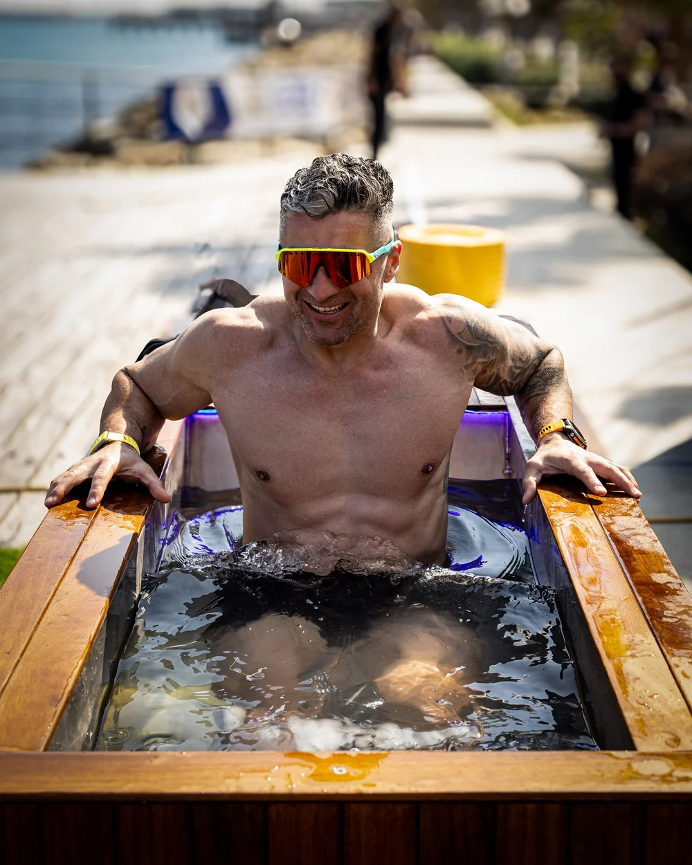 Man rising out of a Pagoc ice bath outdoors, water running off him