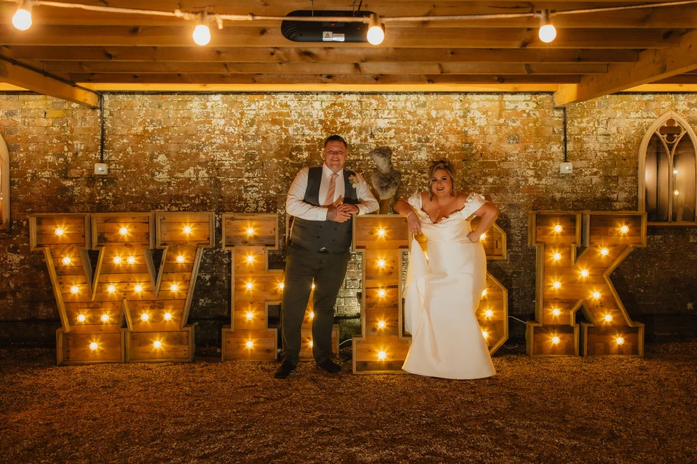 Bride and groom in front of light-up letters