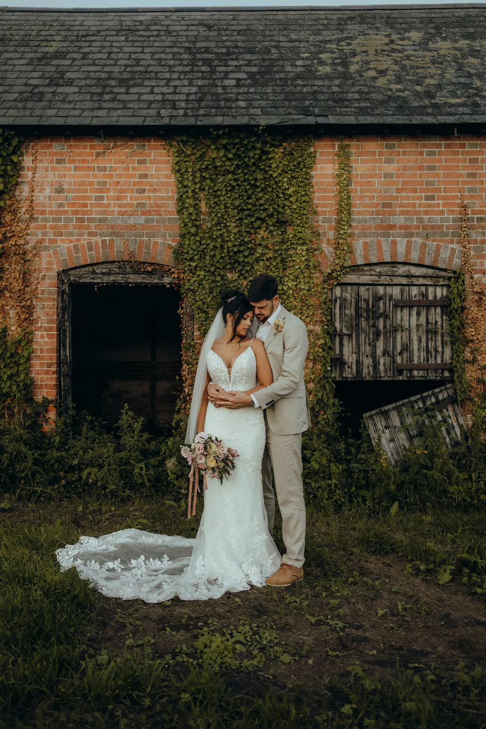 Couple outside an ivy-covered barn