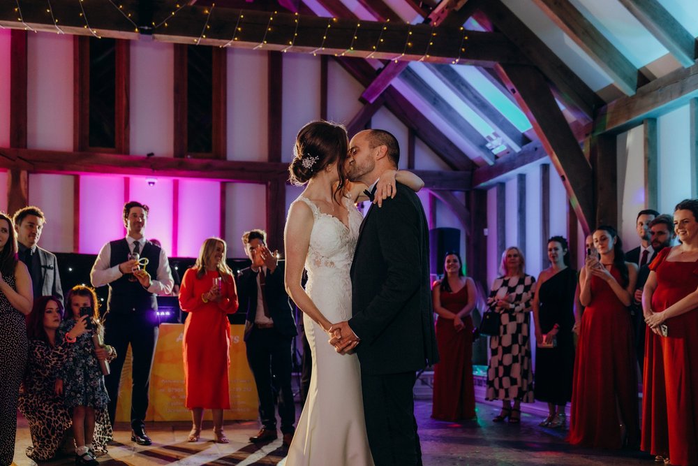 Couple kissing on a colourfully lit dance floor