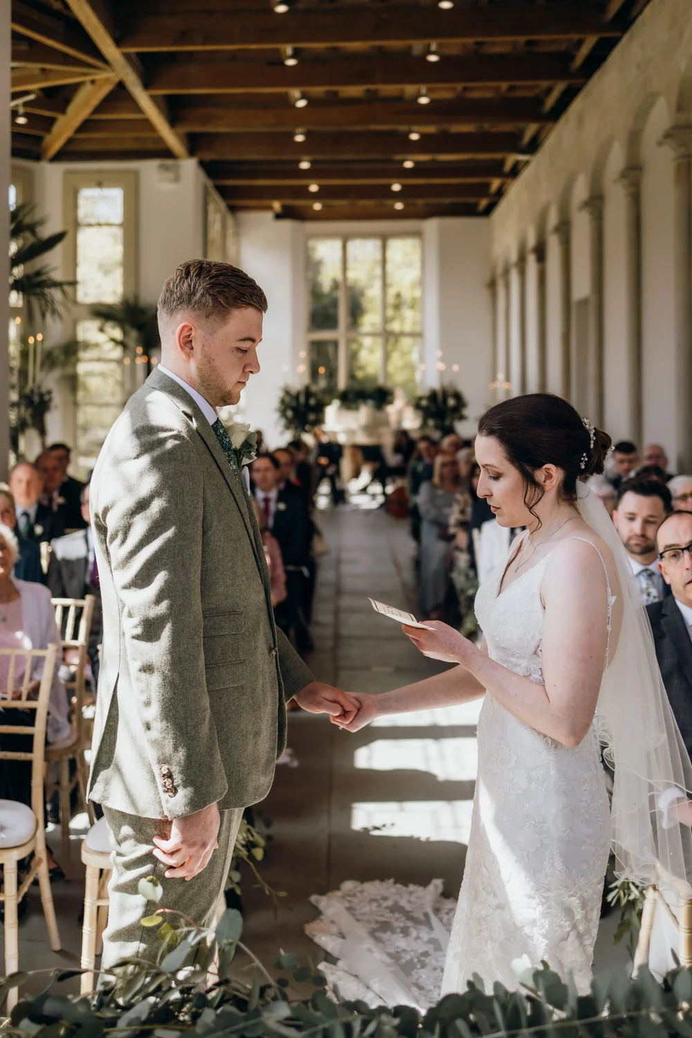 Couple reading their vows in a light-filled orangery
