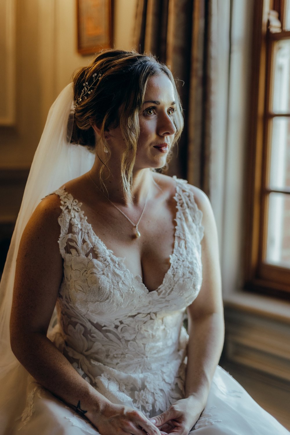 Bride in her dress sitting by the window