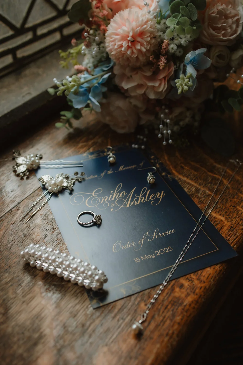Order of service, rings and bouquet laid out on a table