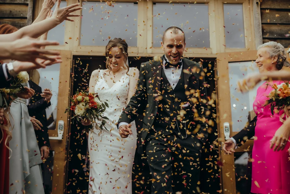 Confetti falling over the couple in a doorway