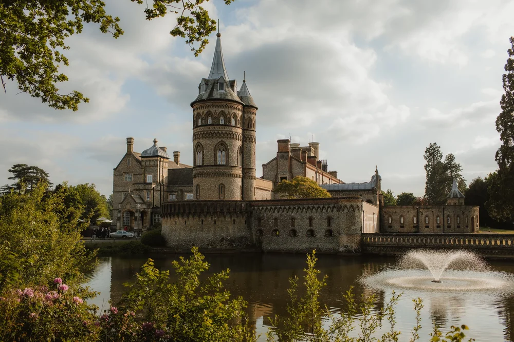 A castle wedding venue with a fountain in the lake