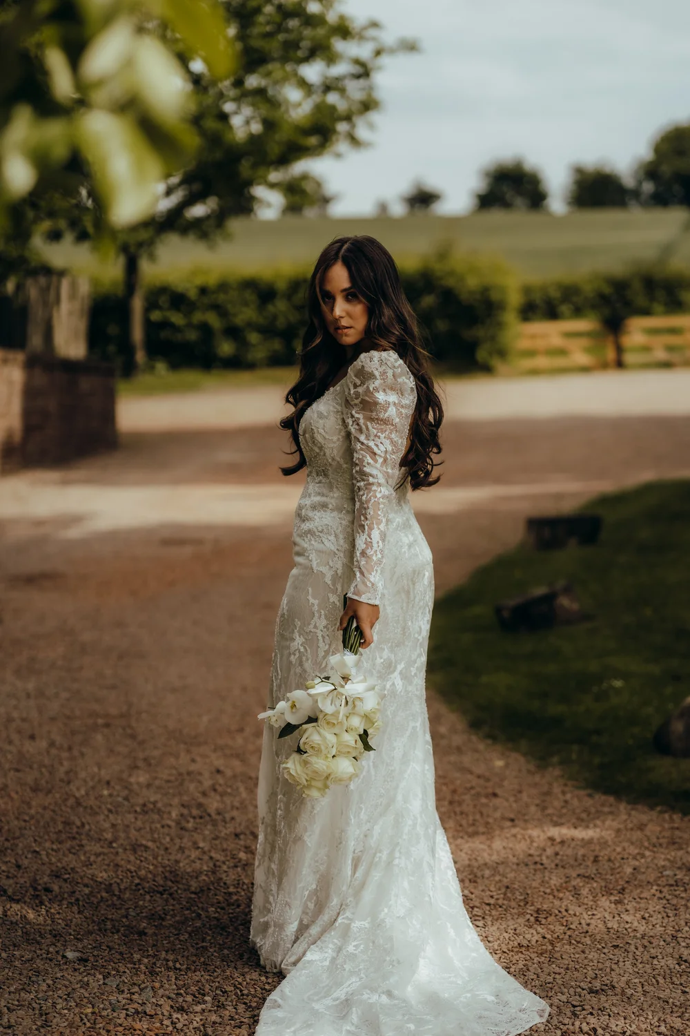 Bride with her bouquet on a garden path