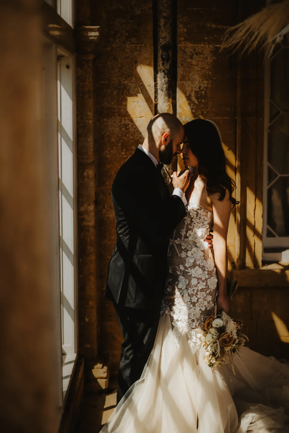 Couple embracing in warm window light