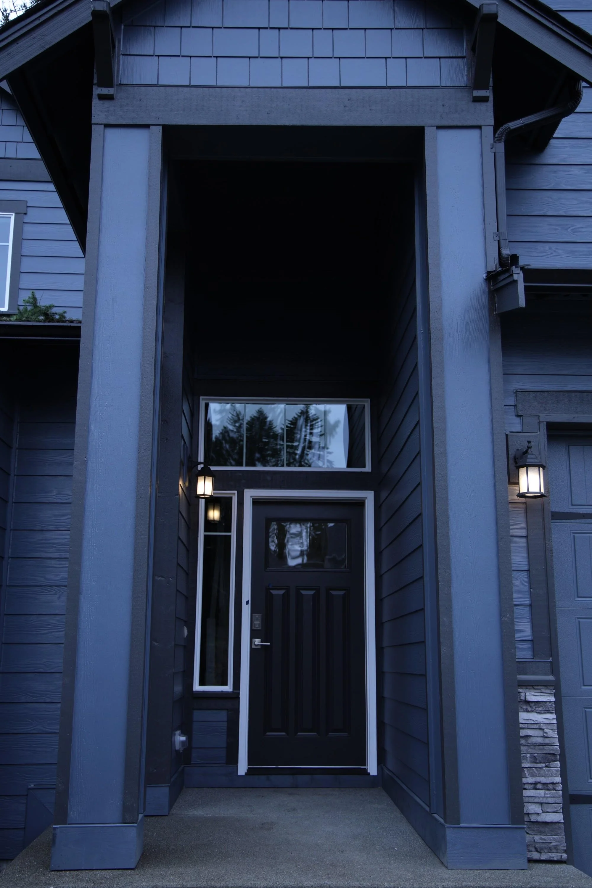 Dark siding and trim surrounding a covered front entrance