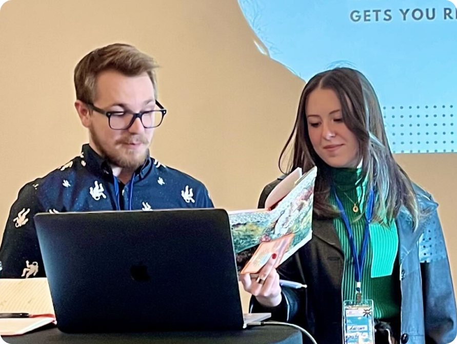two creative professionals looking at a laptop together
