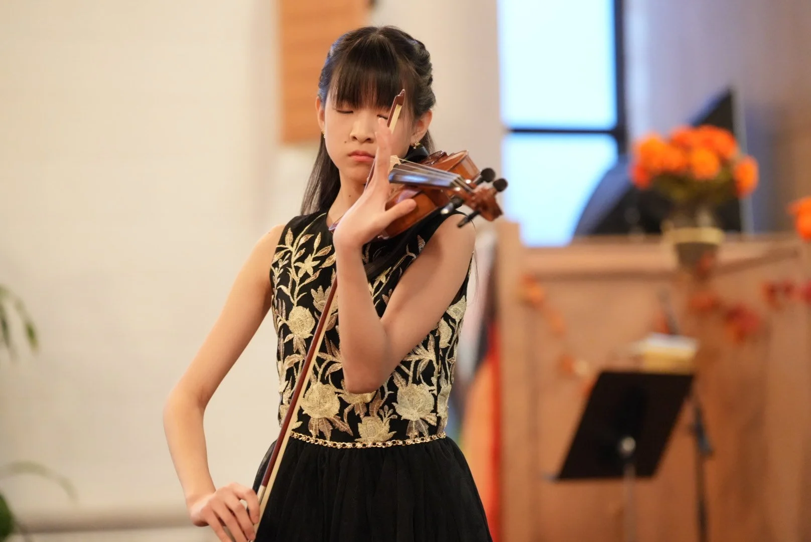 Student playing violin at a studio recital