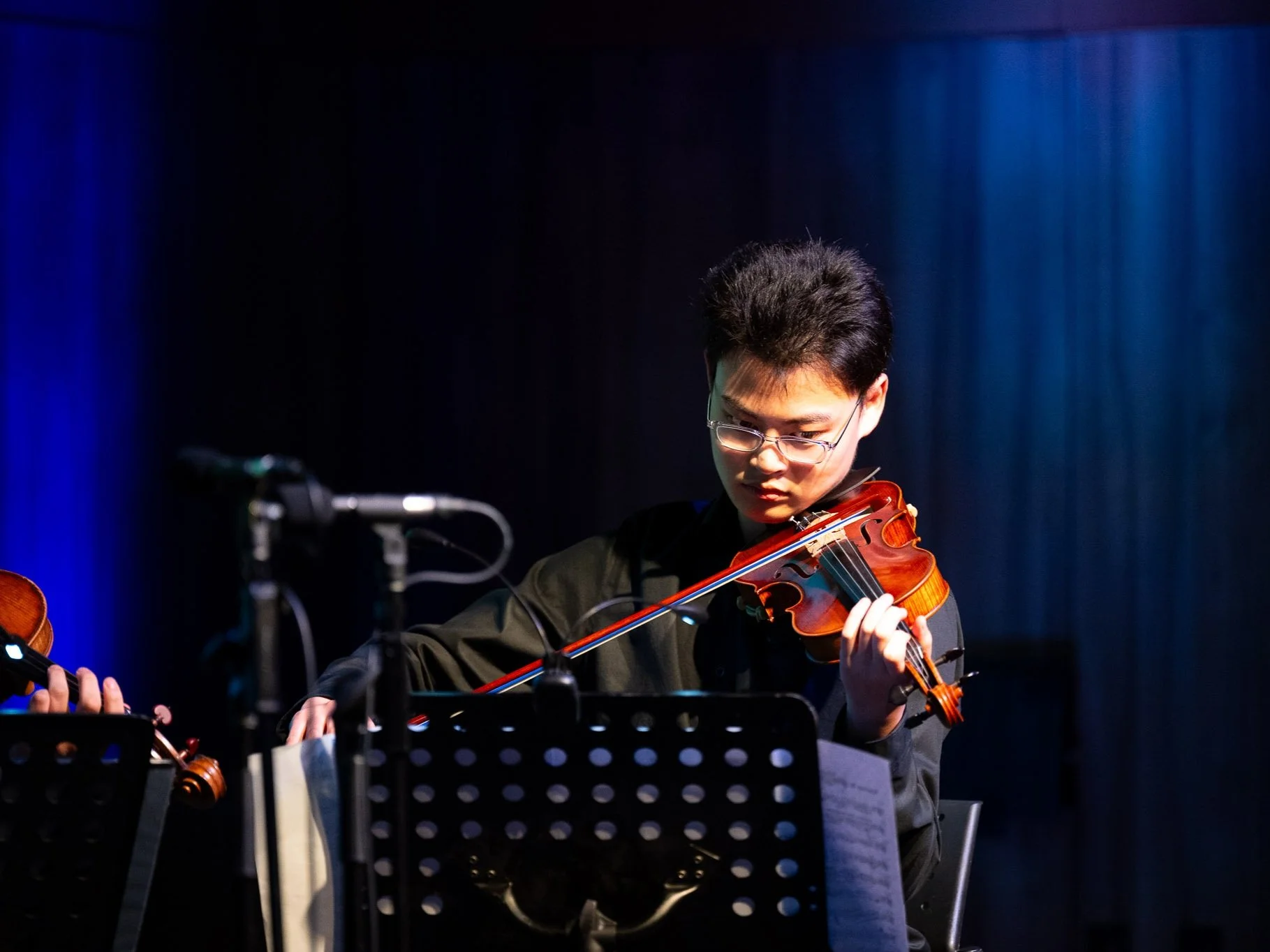Student playing violin in a studio session