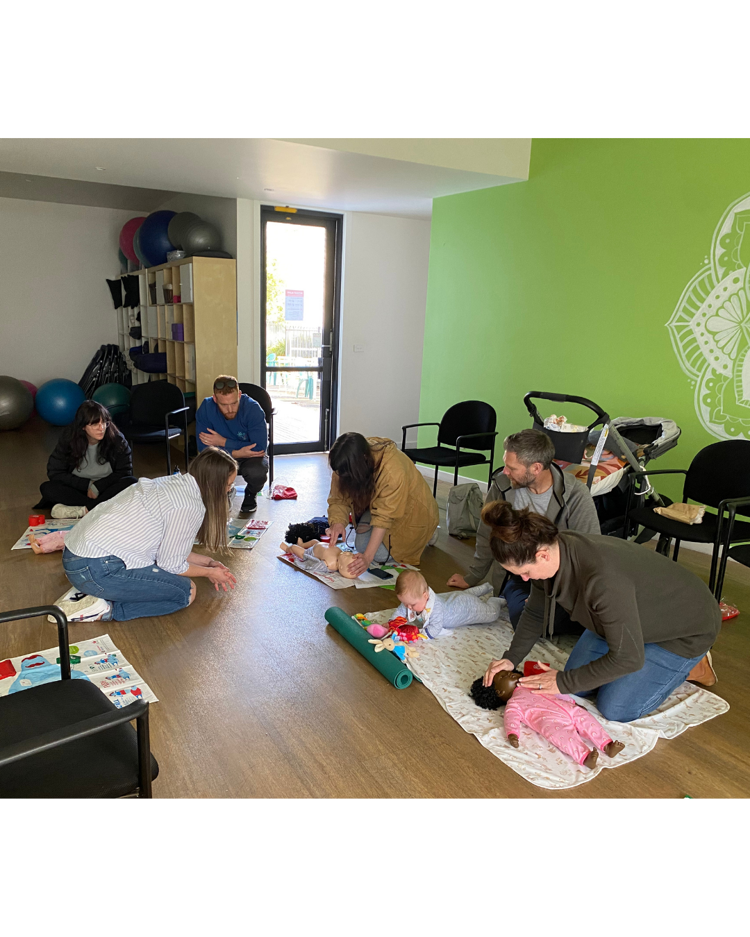 Parents practising baby first aid techniques at a MAMA workshop