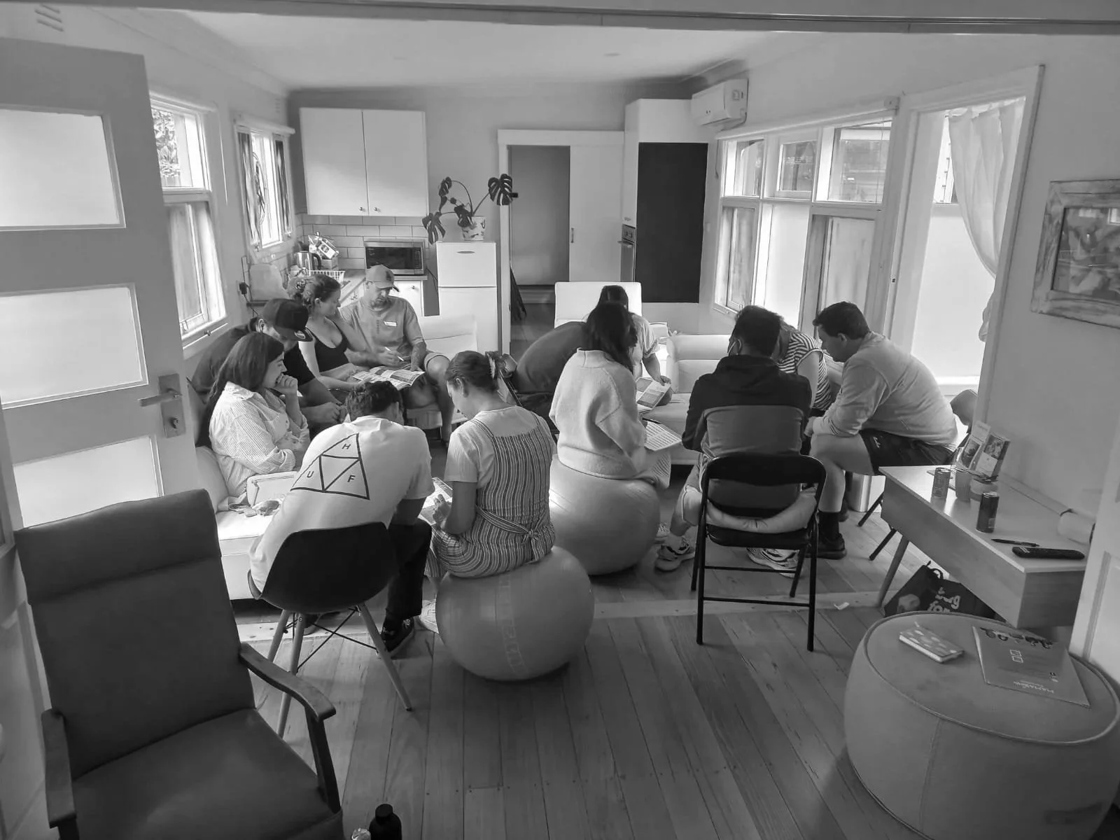 Parents sitting in a circle discussing birth preparation in a cozy kitchen setting