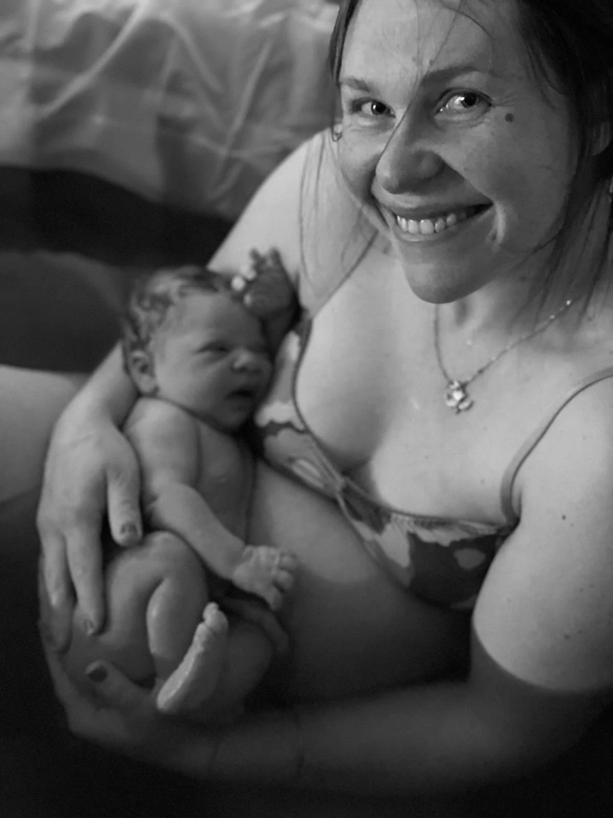 A smiling mother holding her newborn