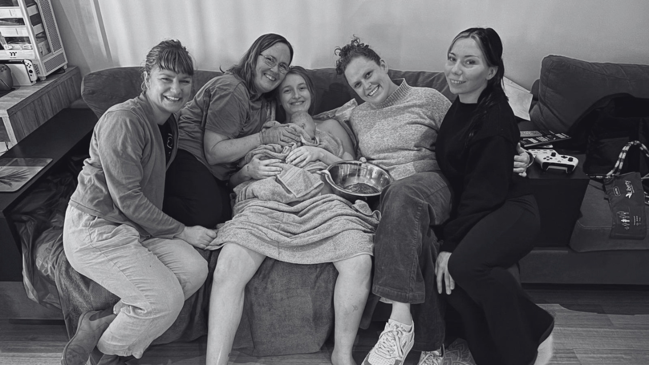 Midwife supporting mother and baby