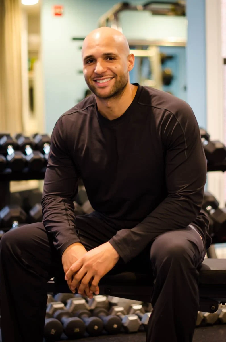 Earl Strong seated beside dumbbells in the gym