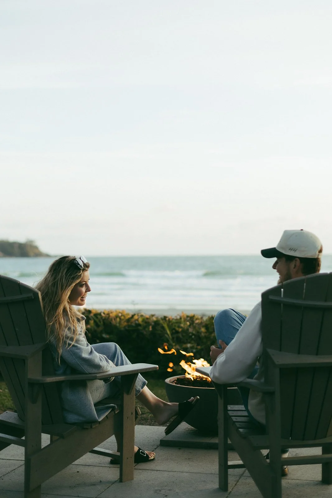 A couple in Adirondack chairs looking out at the ocean