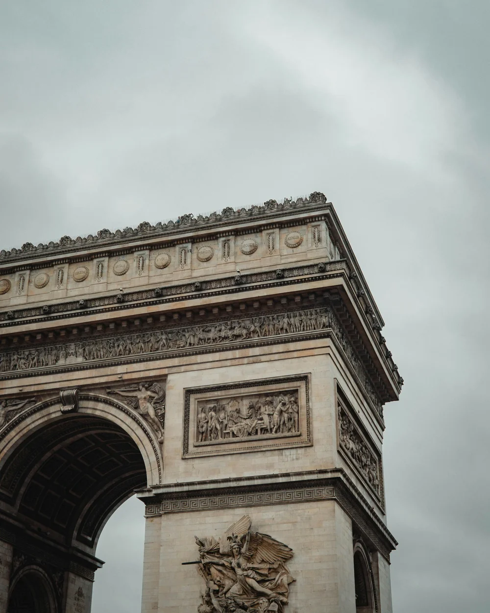 The Arc de Triomphe in Paris under a cloudy sky