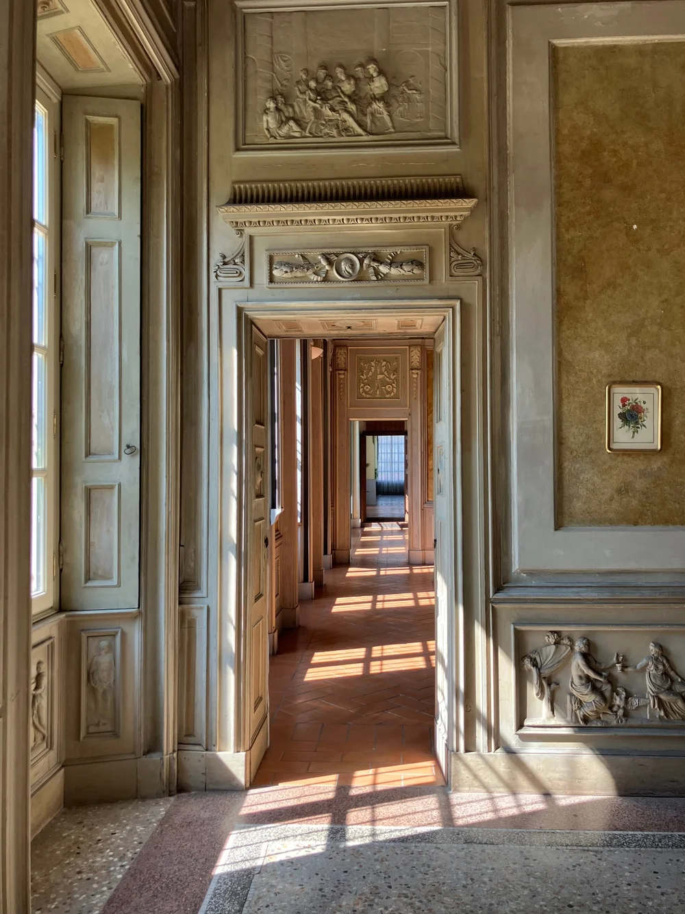 A sunlit corridor of open doorways in an Italian palazzo