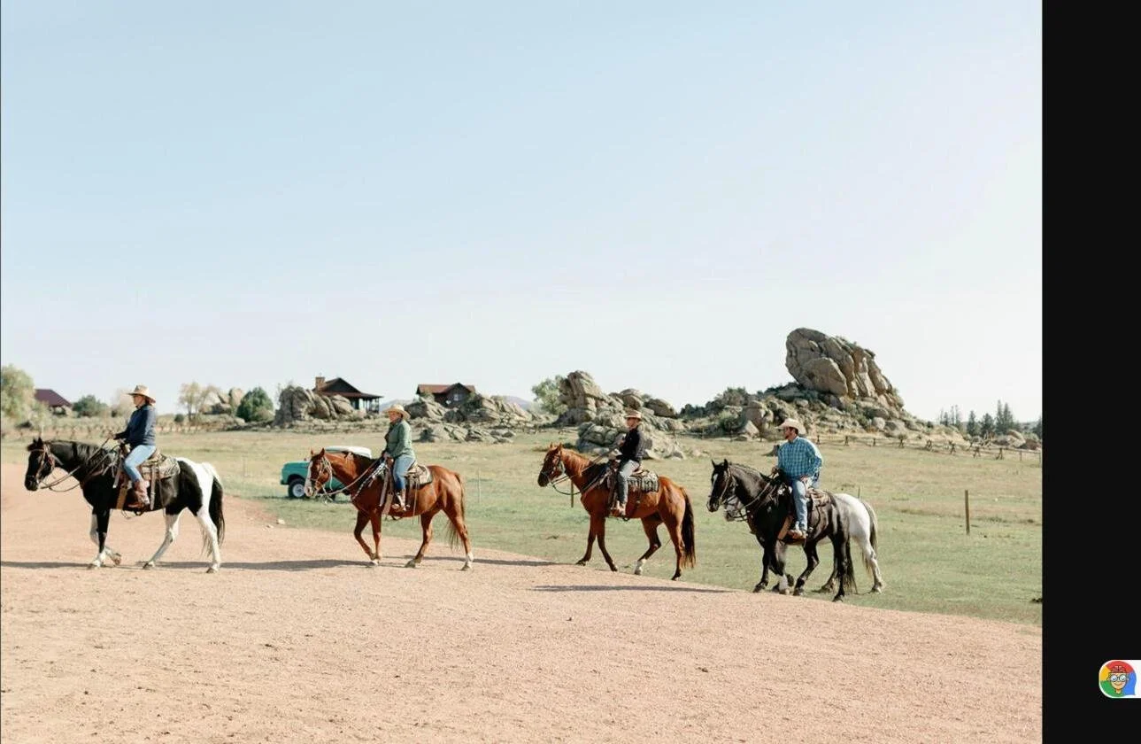 Family riding out across the meadow at Brush Creek Ranch