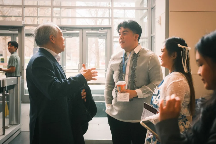 A senior physician in conversation with students wearing Filipiniana attire