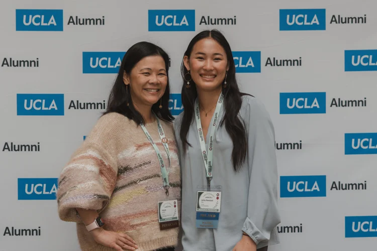 Two attendees in conference lanyards smiling together at a CYFAM conference