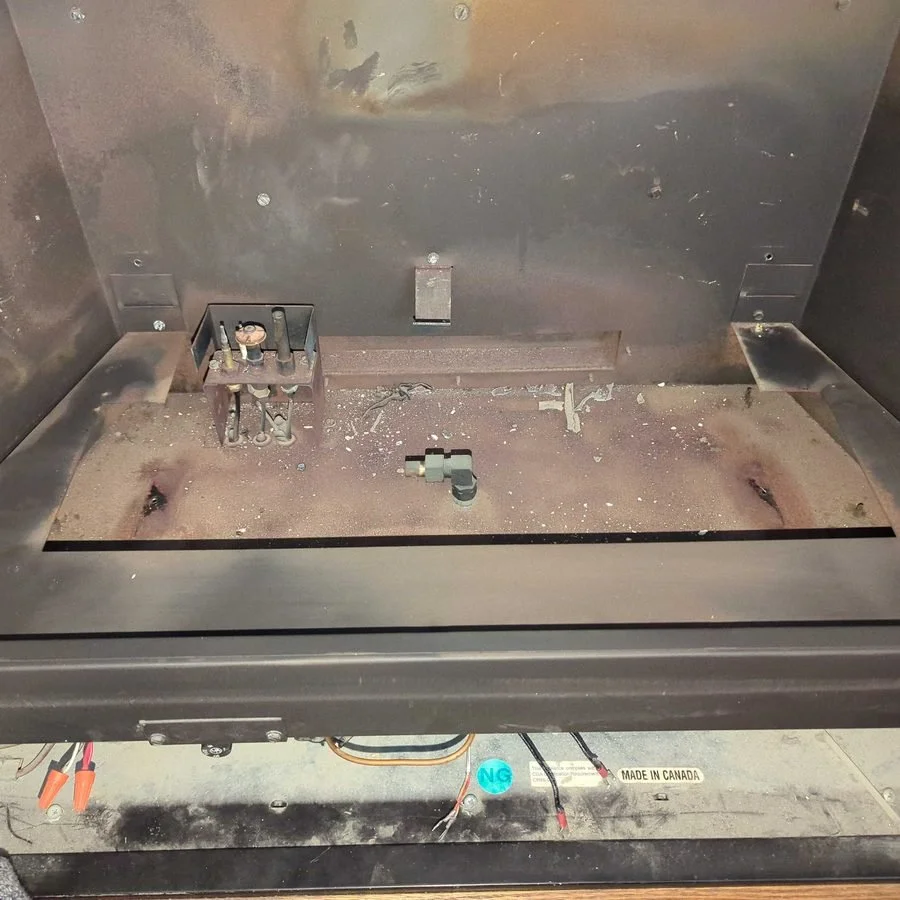 Dirty gas fireplace firebox before cleaning