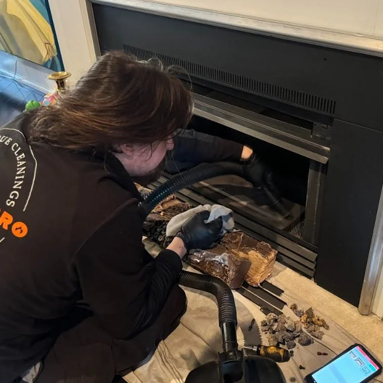 Gas Fireplace Pro technician cleaning a gas fireplace