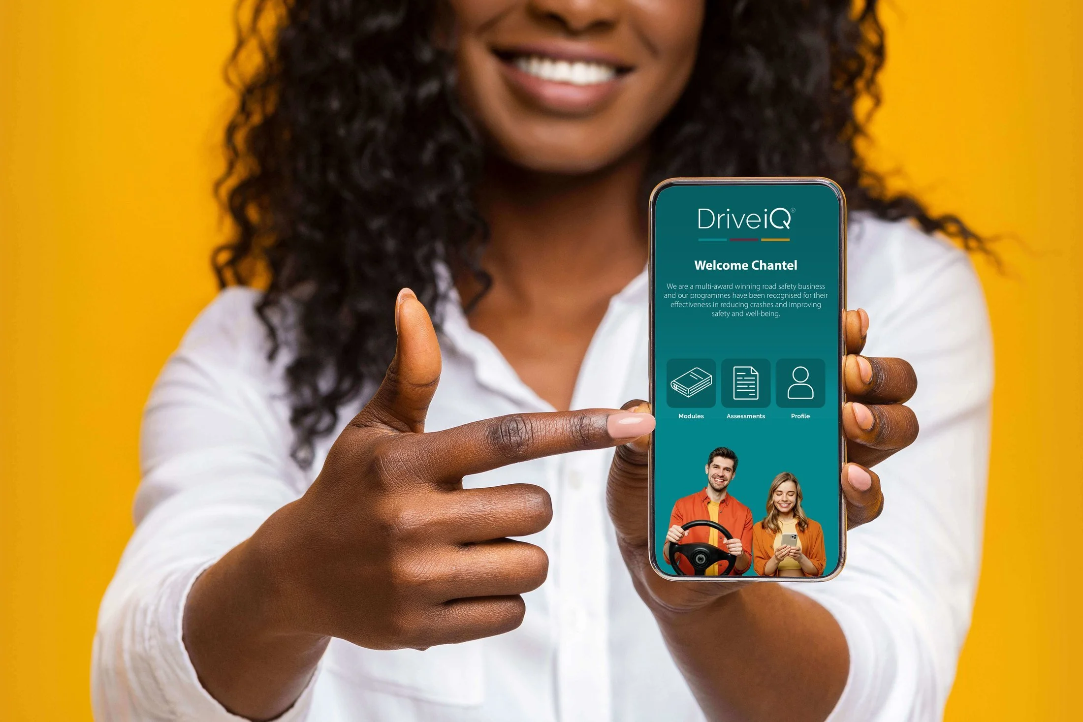 A driver holding a phone showing the Drive iQ app