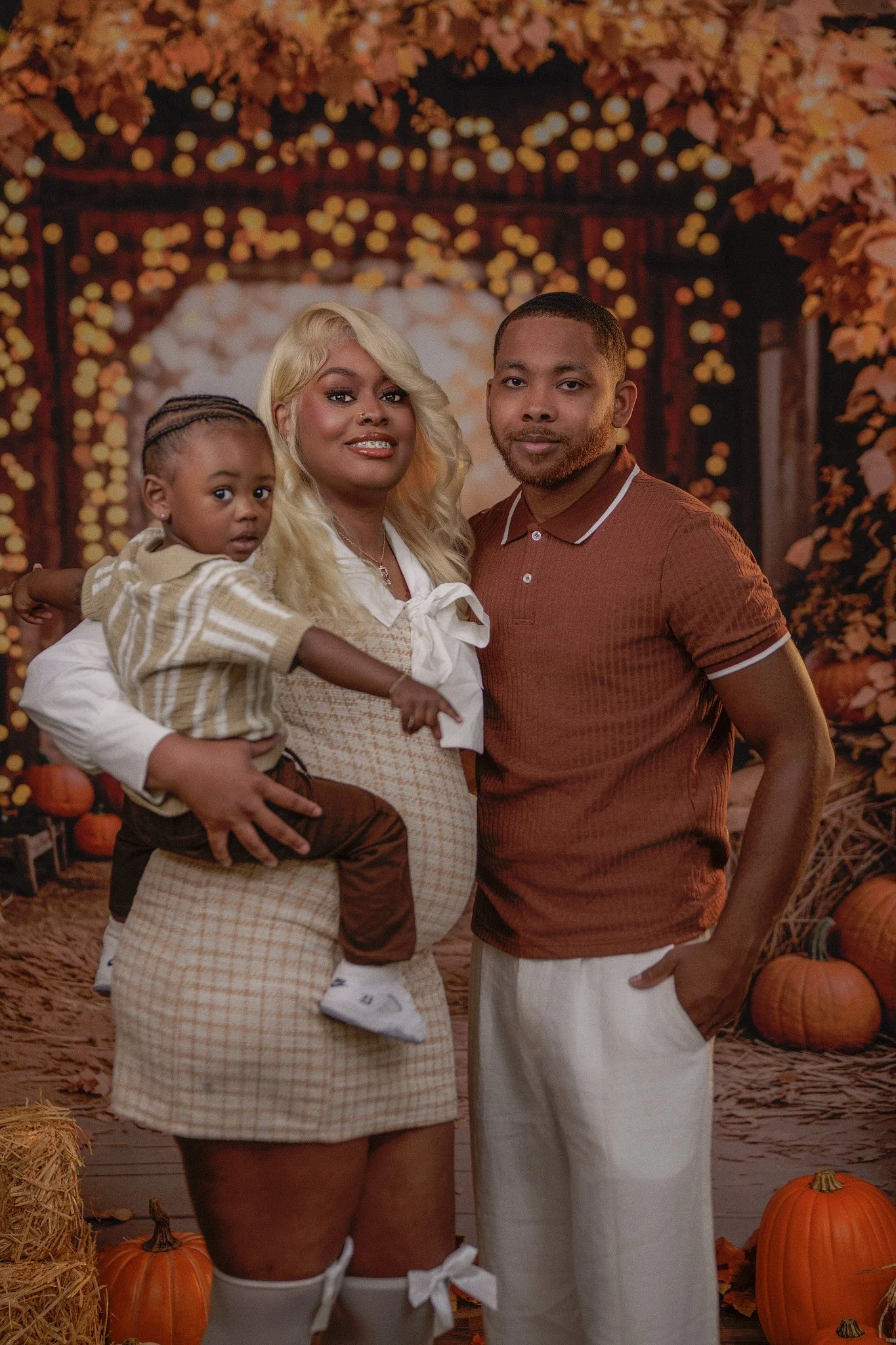 Family of three at autumn backdrop