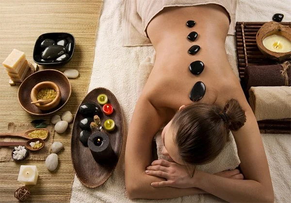 Hot and cold stone massage with heated basalt stones along the spine at Panda Revival Lab in Surrey