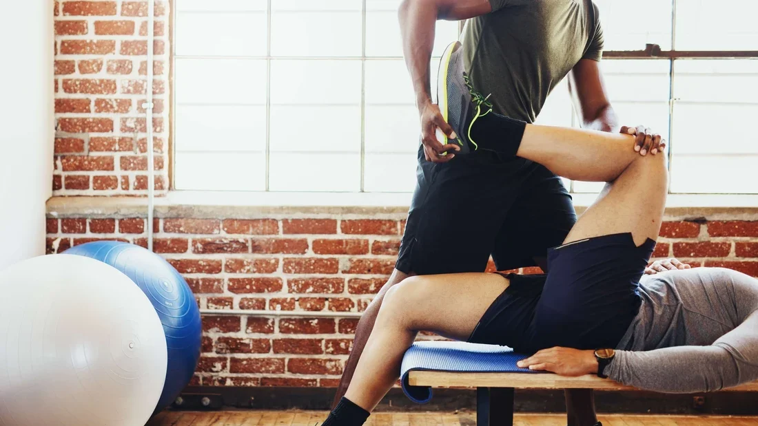 Physiotherapist guiding an assisted hip and hamstring stretch at Panda Revival Lab in Surrey