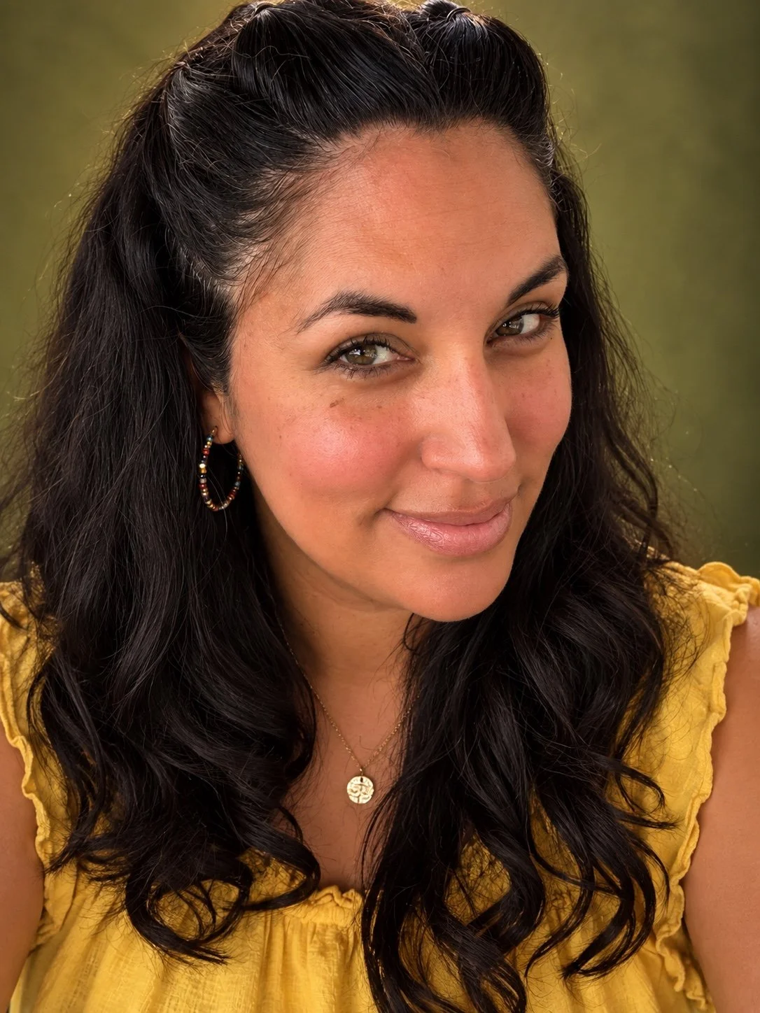 Veronica Pirillo in a sunflower yellow blouse against a green background