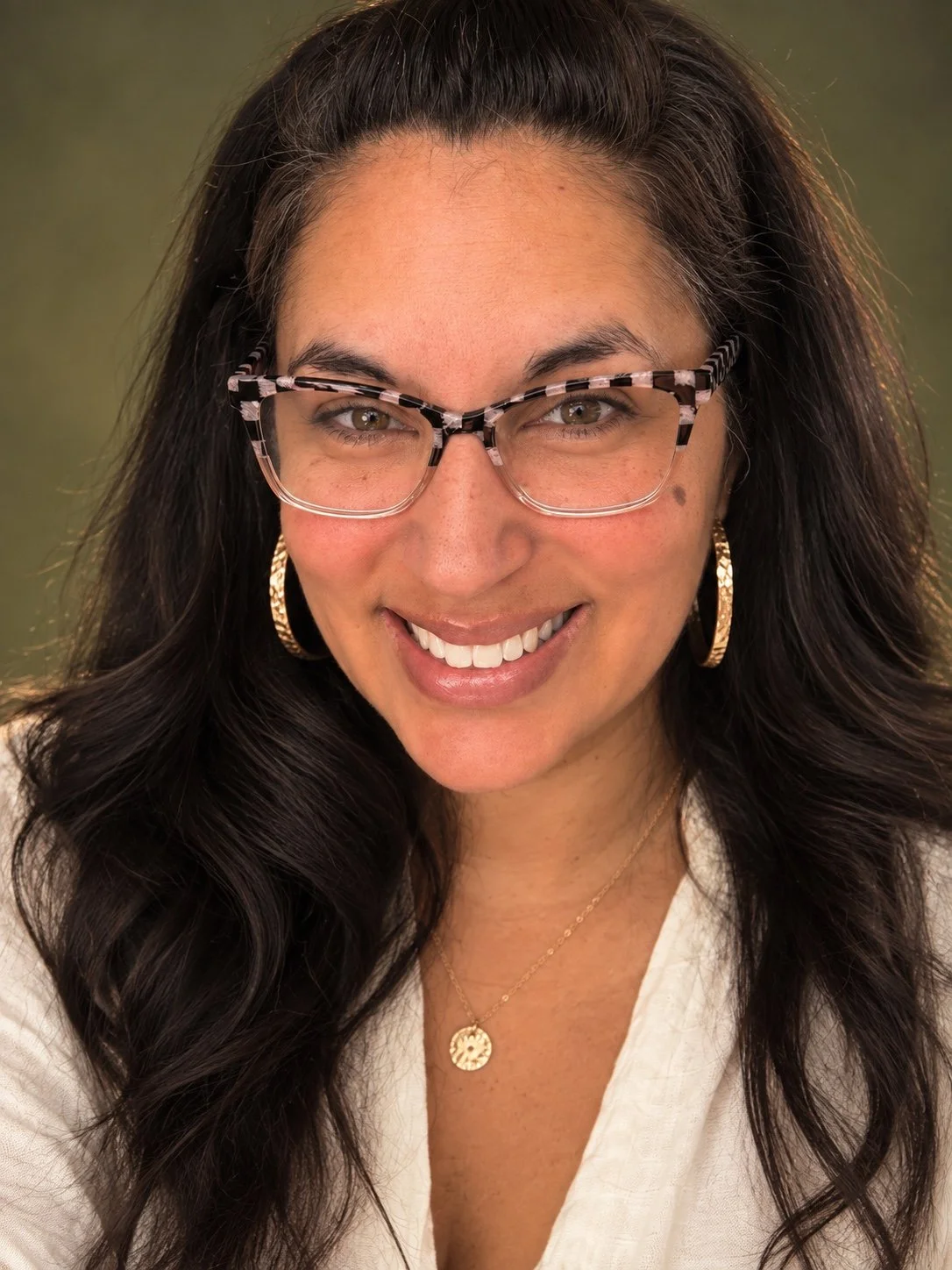 Veronica Pirillo smiling, wearing glasses and a white blouse