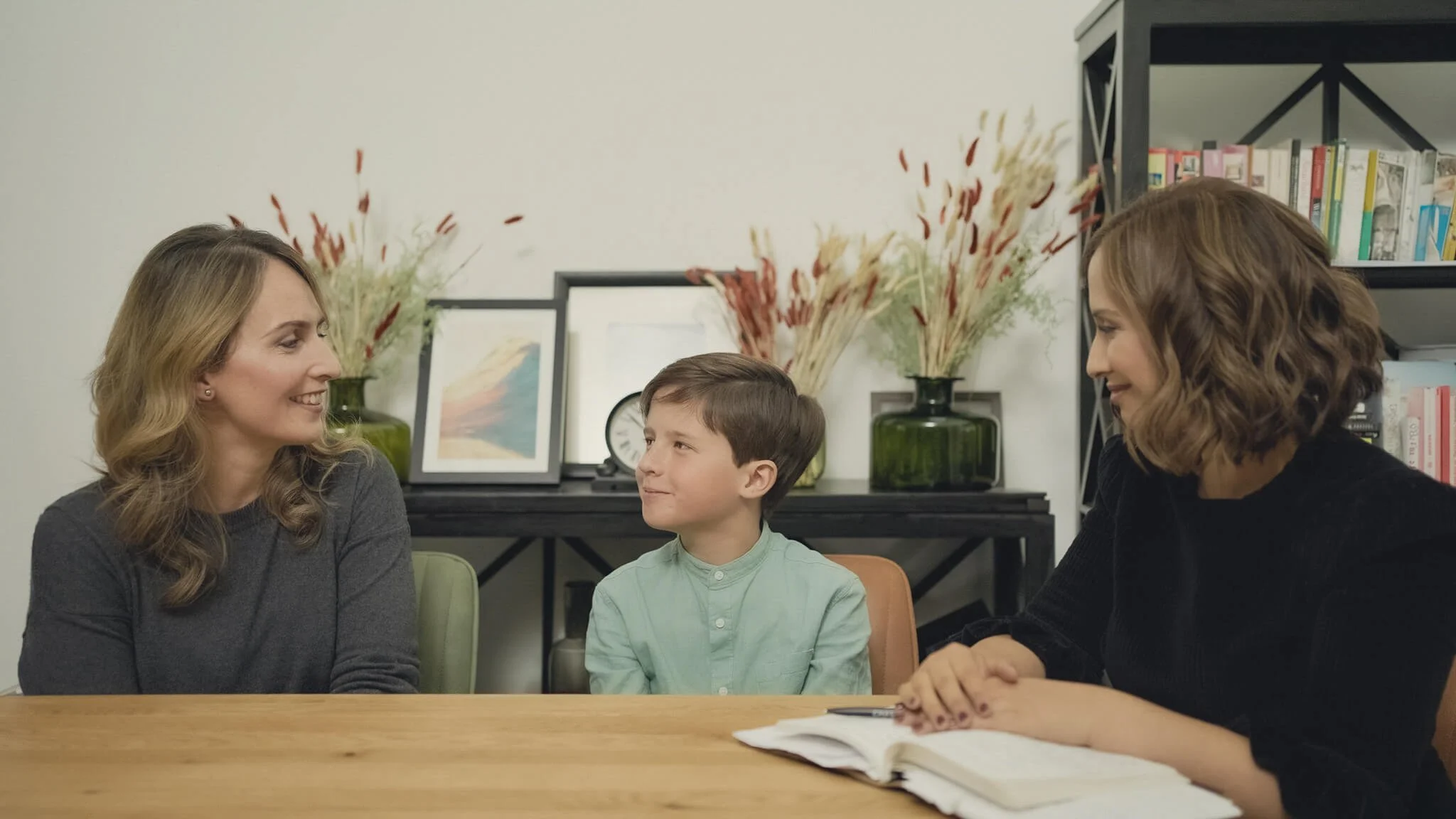 A child and parent speaking with a clinician.