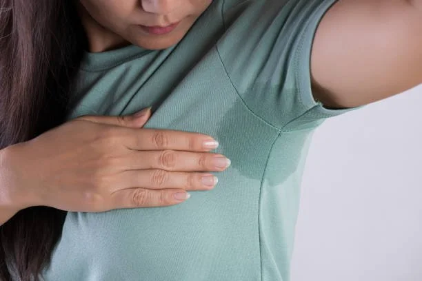 Woman with underarm sweat stain on green shirt