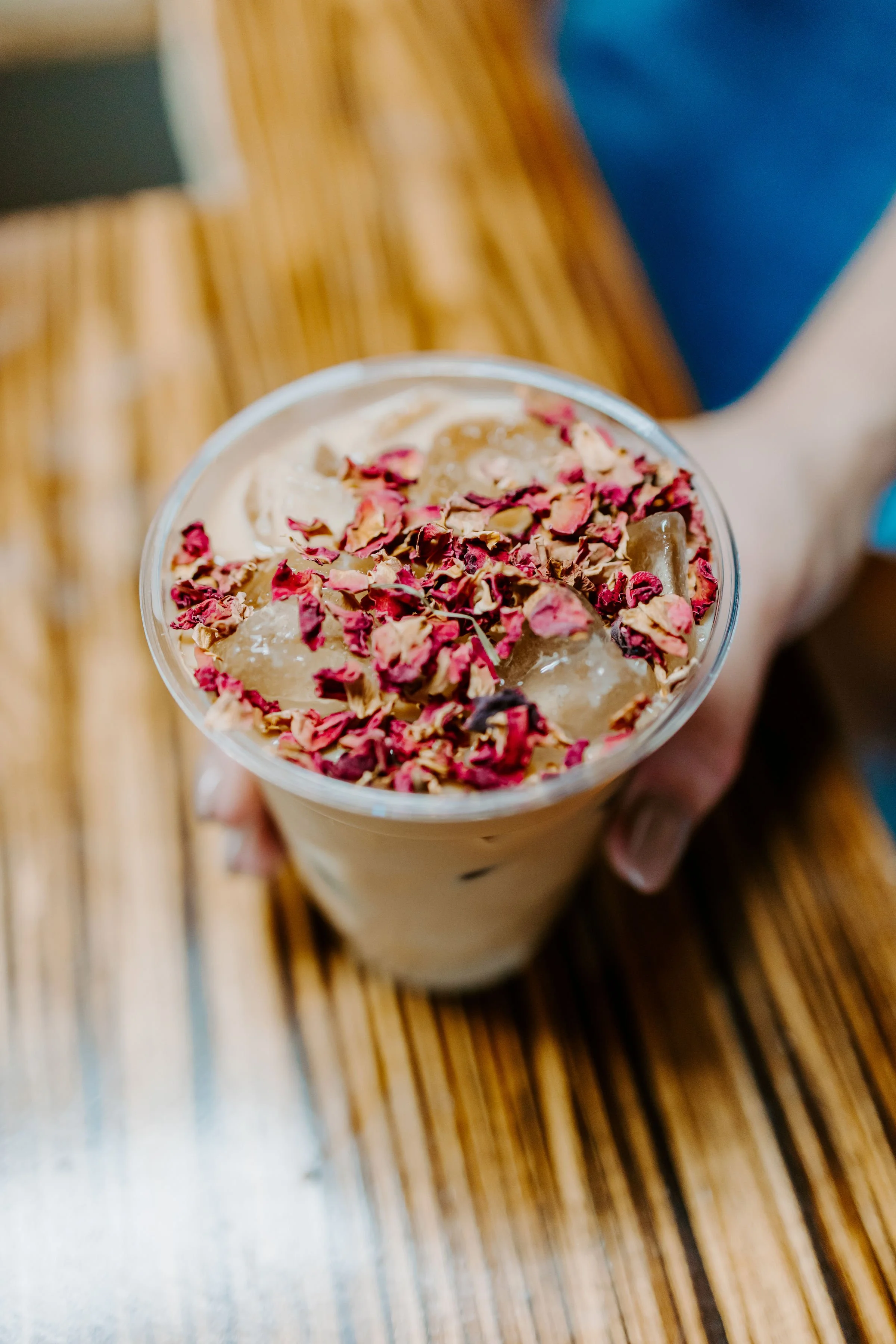 Iced coffee topped with rose petals for a Promise Coffee wedding package